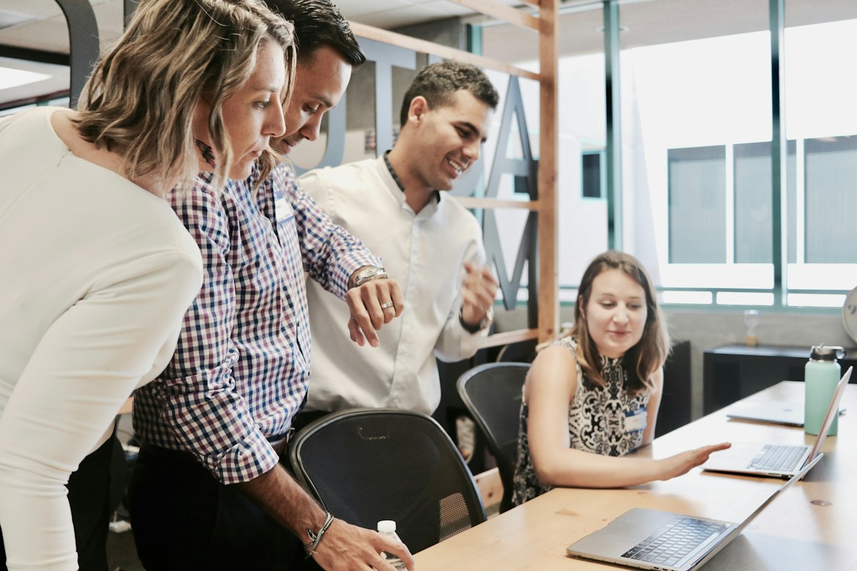 Creative professionals collaborating around a table with laptops
