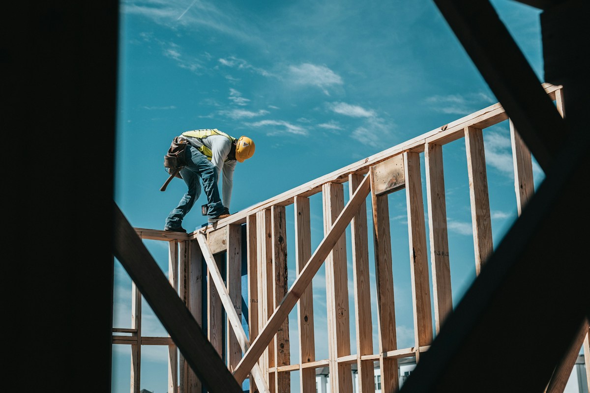 A tradesperson in a hard hat working on a home frame in Houston, Texas